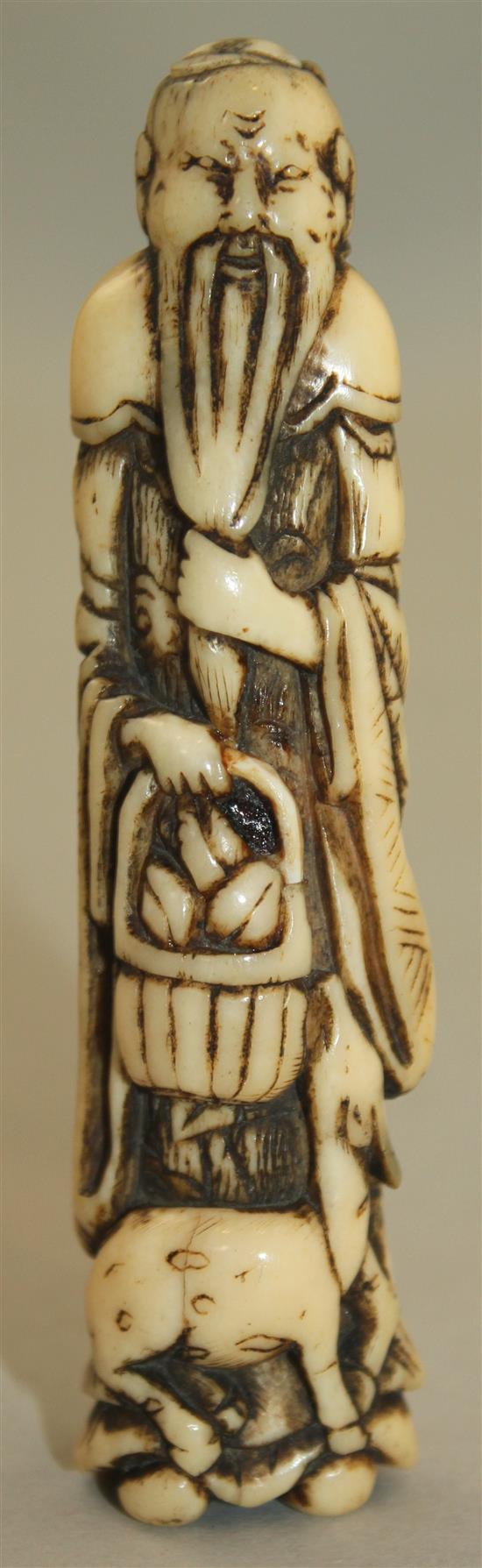 A Japanese stag antler netsuke of a standing sennin, Edo period, 9.8cm